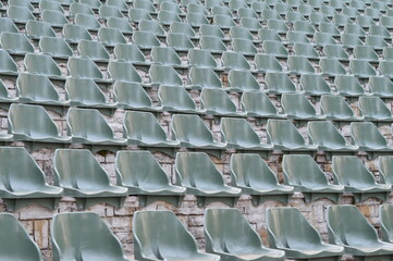 Rows of empty plastic chairs for open-air theater audiences