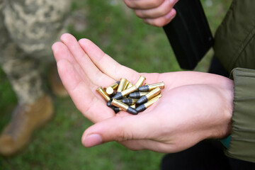 A pile of 22 LR bullets with a round head in the guy's hand.