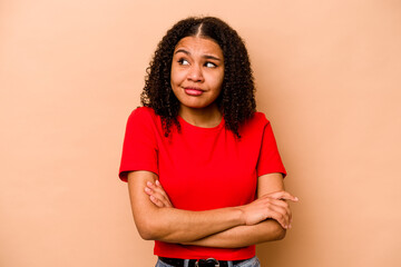 Young African American woman isolated on beige background dreaming of achieving goals and purposes