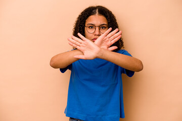 Young African American woman isolated on beige background doing a denial gesture