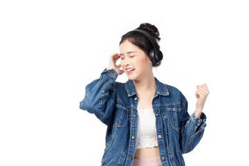 Beautiful young asian woman wearing jeans joyful listening to music on headphones isolated on white background studio portrait.