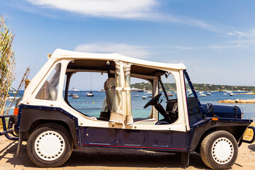 Old vintage car parked on the sandy beach of Nice in France in sunny nice summer weather