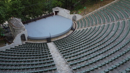 Aerial view of the stage and rows of empty plastic chairs for outdoor theater audiences