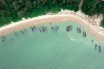 Fisherman long tail boat at shore beach aerial top view greenery tree blue sea