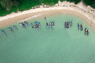 Fisherman long tail boat at shore beach aerial top view greenery tree blue sea