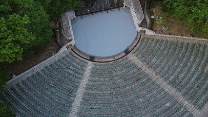 Aerial view of the stage and rows of empty plastic chairs for outdoor theater audiences