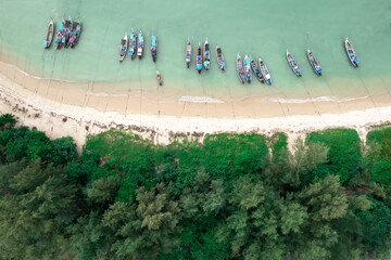 Fisherman long tail boat at shore beach aerial top view greenery tree blue sea
