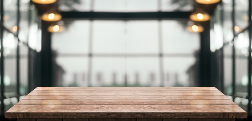 Empty wooden table top with lights bokeh on blur restaurant background.