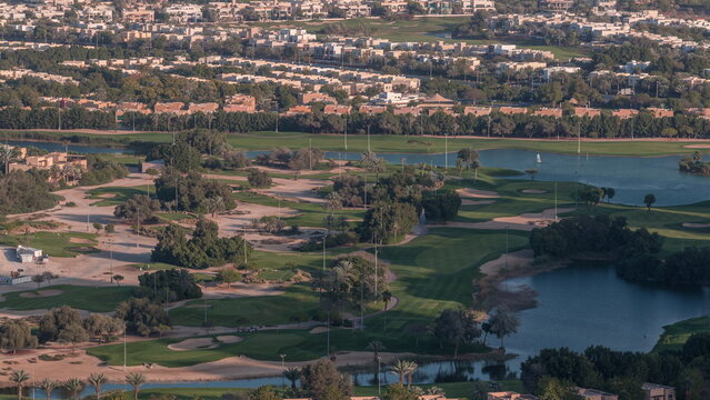 Aerial View To Golf Course With Green Lawn And Lakes, Villa Houses Behind It Timelapse.