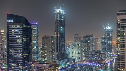 Fototapeta na wymiar Aerial view to Dubai marina skyscrapers around canal with floating boats night timelapse