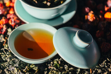 Chinese tea ceremony close-up selective focus. Brewing green Chinese tea in gaiwan during the tea ceremony close-up. Gaiwan and other tea accessories for the ceremony. Oolong. Puer. Da Hong Pao.