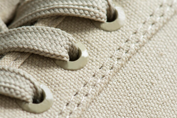 Lacing of textile sneakers close-up. New sport shoe laced up, side view. Elastic shoes of modern mesh fabric trainers for fitness, sport exercises and active lifestyle.
