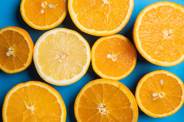 oranges and tangerines cuts on half, blue background, citrus 