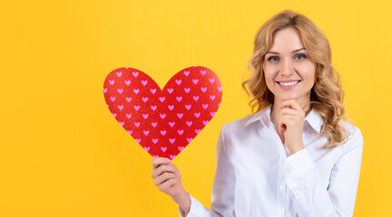 happy woman with red love heart on yellow background. romantic gift
