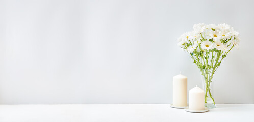 Home interior with decor elements. White flowers in a vase on a light background