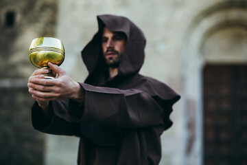 The Monk holds the holy grail in his hand.