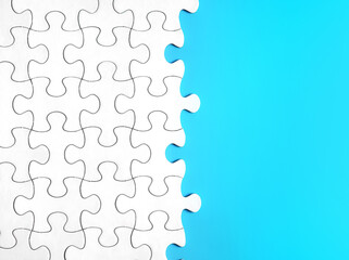 Jigsaw Puzzle on Blue Background with copy space. Business strategy teamwork and problem solving concept. Teamwork is collaborative effort of team to achieve goal or to complete task.                 