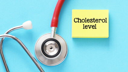 Cholesterol level words on a yellow piece of paper and blue background.