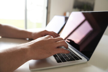 The concept of remote work. Close-up of male hands typing on the keyboard in search of information....