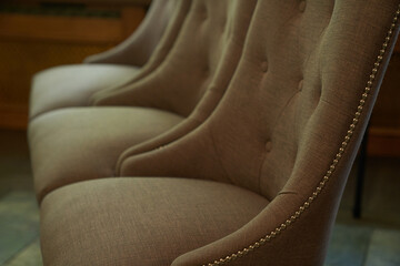 Beige velvet seats for guests in the theater. Rows of empty sand chairs in the theater hall. High...