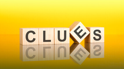 clues - text of on wooden cubes, reflected from the bright yellow surface