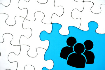 Team or teamwork symbol on blue background surrounded by puzzle pieces. Business success concept.                          