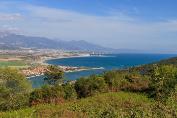 Top view of the Magra river's mouth on the border between Liguria and Tuscany in Italy. On the background are the mountain range of the Apuan Alps. - 505019169