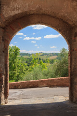 Typical tuscan landscape viewed through the gate of the walls (Italy) - 505019195