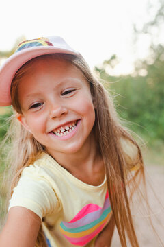 Close-up portrait of happy little girl in sunny summer day outdoor