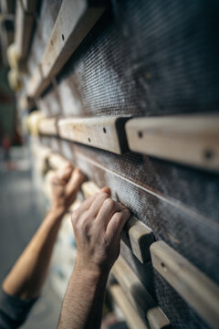 Person's hand holding on to a finger board at a climbing gym