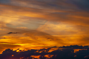 beautiful dramatic sunset sky, bright sunlight and dark silhouette of clouds as a background