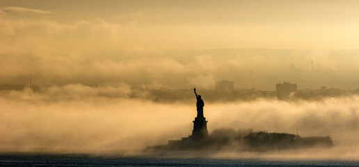 Statue of Liberty in the fog at sunset - obrazy, fototapety, plakaty