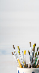 Obraz premium Group of old used paintbrushes in jar,soft focus and shallow depth of field composition.