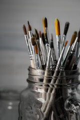 Group of old used paintbrushes in jar,soft focus and shallow depth of field composition.