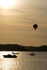 A  hot air balloon flying over the River Exe as seen from Lympstone village, Devon, UK