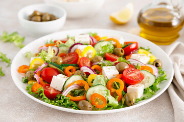 Greek salad with feta cheese, tomatoes, cucumbers, pepper, red onion and green olives. Top view