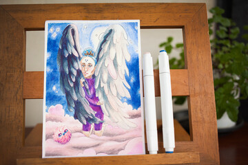 Hand drawn marker art on paper depictung female bird angel with face of a sad woman on a pink cloud. Drawing picture at home studio using alcohol markers.