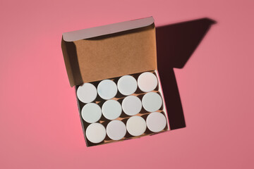 paints with white caps in an open box on a colored background