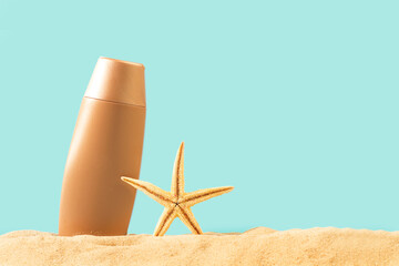 Botella de crema de protección solar sobre un fondo de arena junto a una estrella de mar y un...