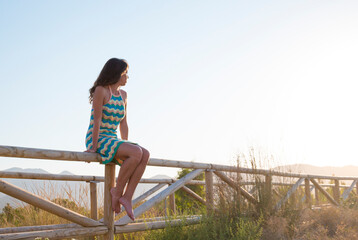 Joven mujer disfrutando relajada de un atardecer veraniego junto al mar Mediterráneo