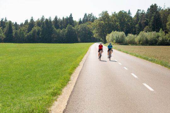 Man and woman couple road cycling on race bike outdoor in nature