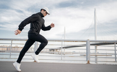 Male athlete runner training to run fast on the street in sportswear