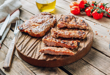 Fresh delicious juicy steaks with on a rustic wooden background. Pork steaks with tomato and mustard sauce