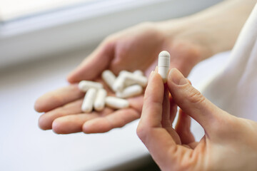 Human hand with white pills in the palm. Medical concept for the treatment of diseases with drugs....