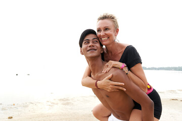 Fototapeta premium Couple in love piggyback riding on a tropical beach