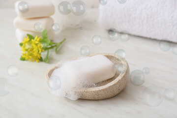 Soap bar with foam on light background