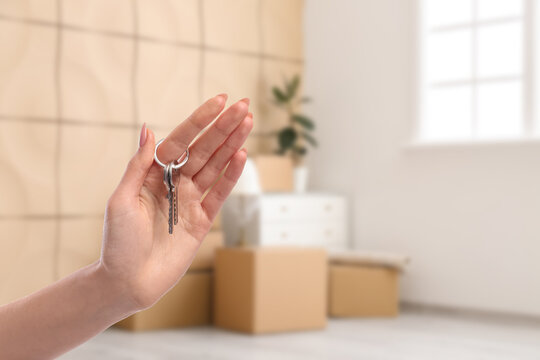 Hand of woman holding key from new house, closeup