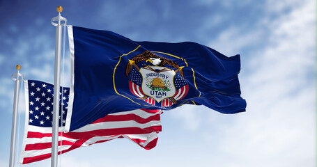 The Utah state flag waving along with the national flag of the United States of America
