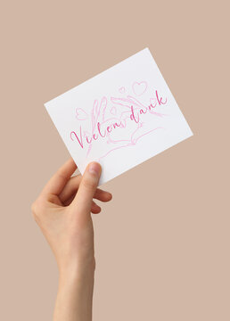 Female hand holding card with text VIELEN DANK (German for Thanks a lot) on color background