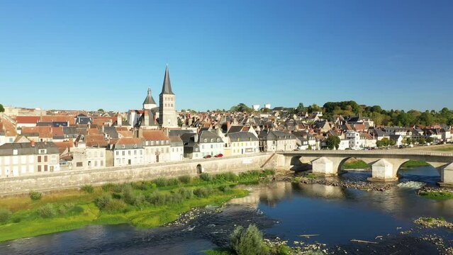 The medieval town center of Charite sur Loire in front of its Loire bridge in Europe, France, Burgundy, Nievre, in summer, on a sunny day.